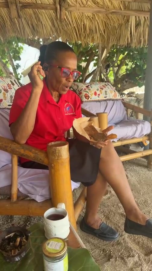 A member of the Coral Cove team enjoying a quiet moment beneath a thatched pavilion