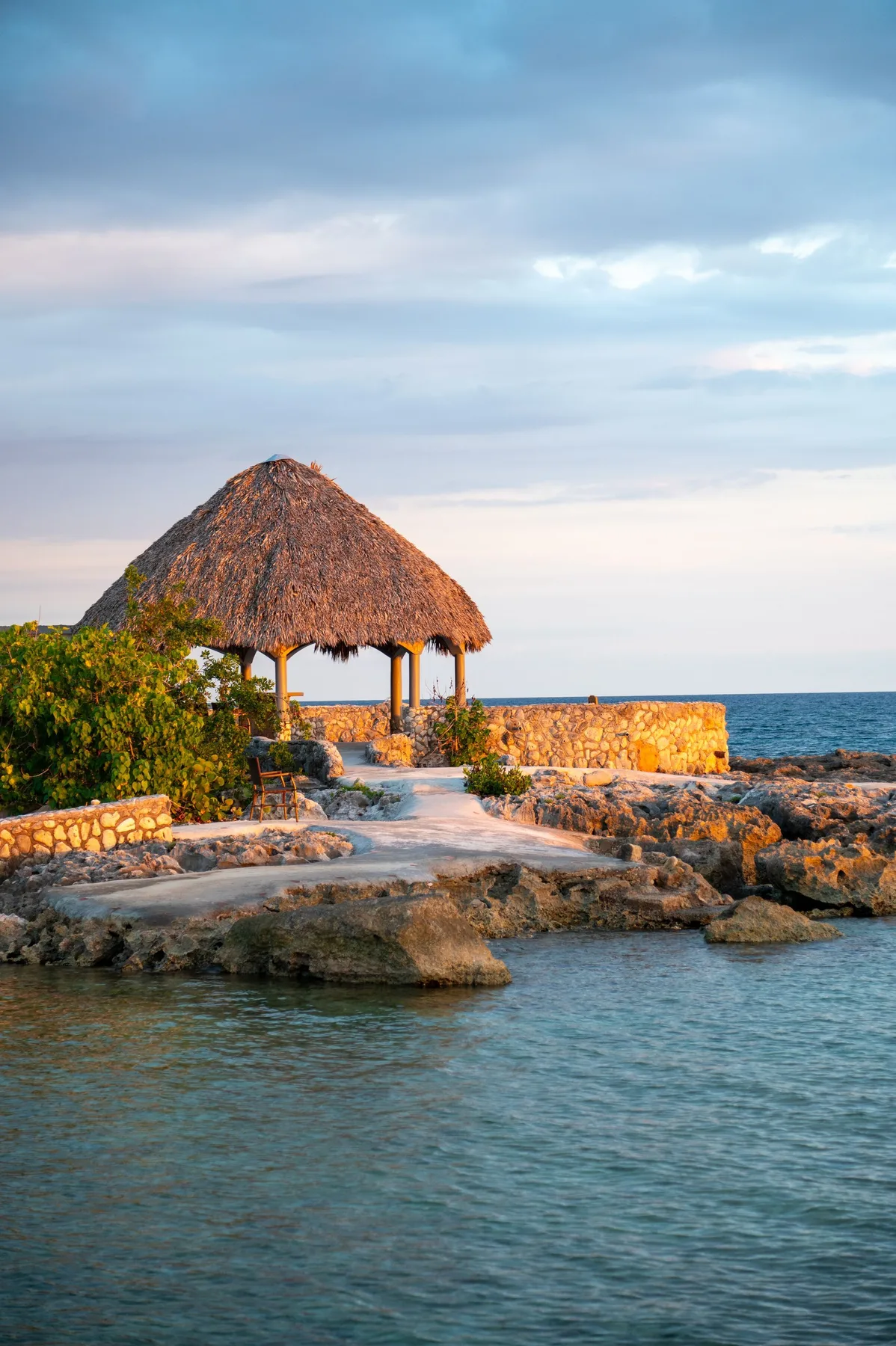 The thatched open-air treatment pavilion on the rocks at the Caribbean Sea