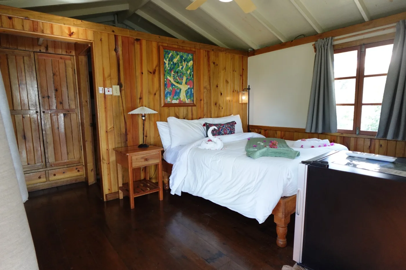 Wood-lined queen bedroom — Sunset Cottage, Coral Cove Wellness Resort
