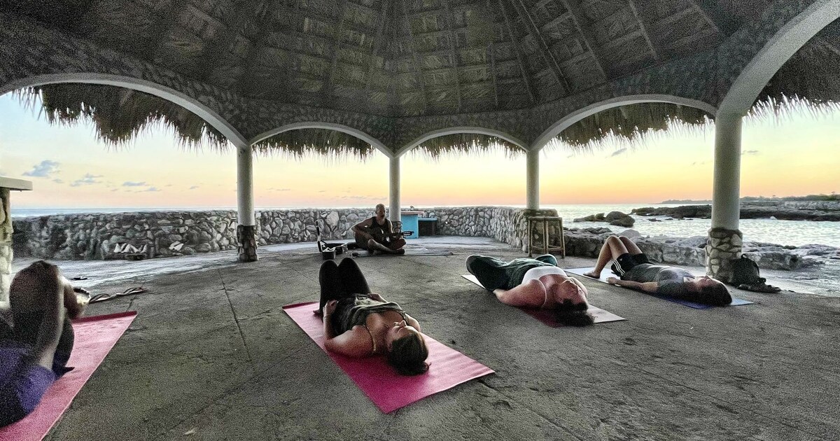 Guests practicing yoga in Coral Cove's open-air seaside pavilion